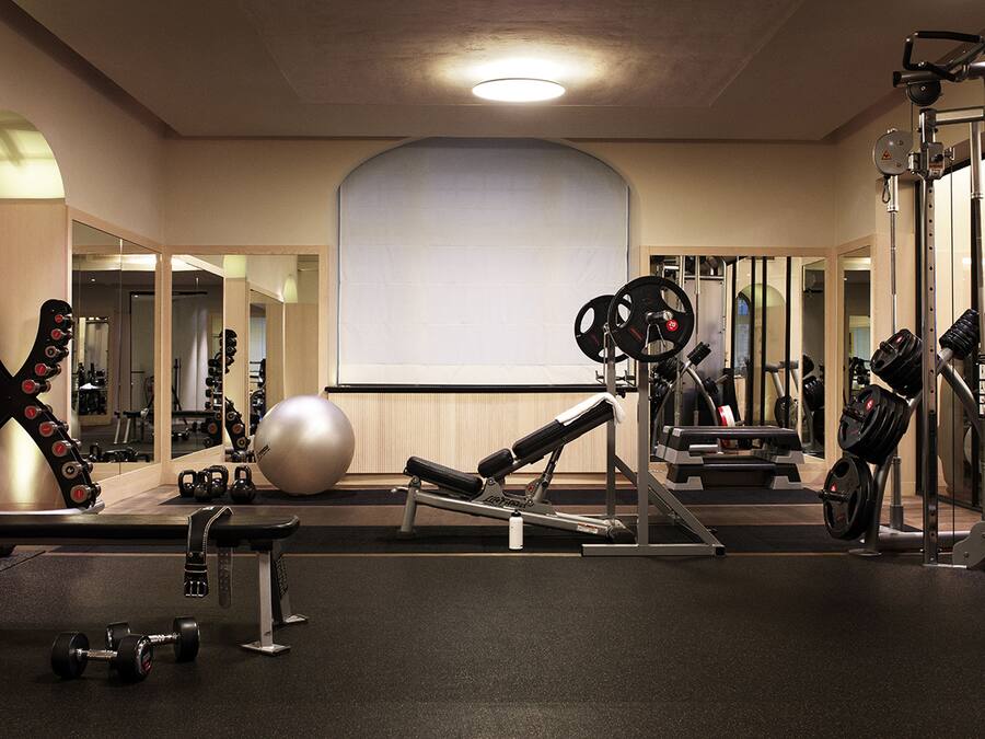 A gym with exercise equipment, a large mirror, and a whiteboard on the wall.