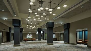 A spacious lobby with a high ceiling, multiple columns, and a patterned carpet.