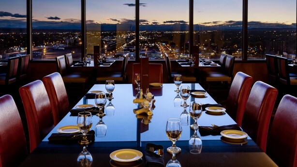 A restaurant with a panoramic city view at dusk. - DoubleTree by Hilton Hotel Billings (Billings)