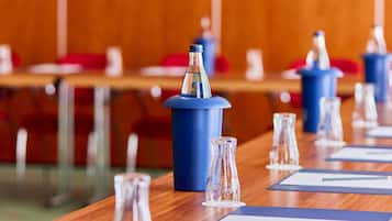 A conference room with tables, chairs, and blue podiums.