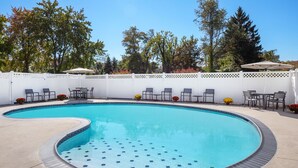 A swimming pool with a white fence, chairs, and tables around it. - Residence Inn by Marriott Cherry Hill Philadelphia (Cherry Hill)