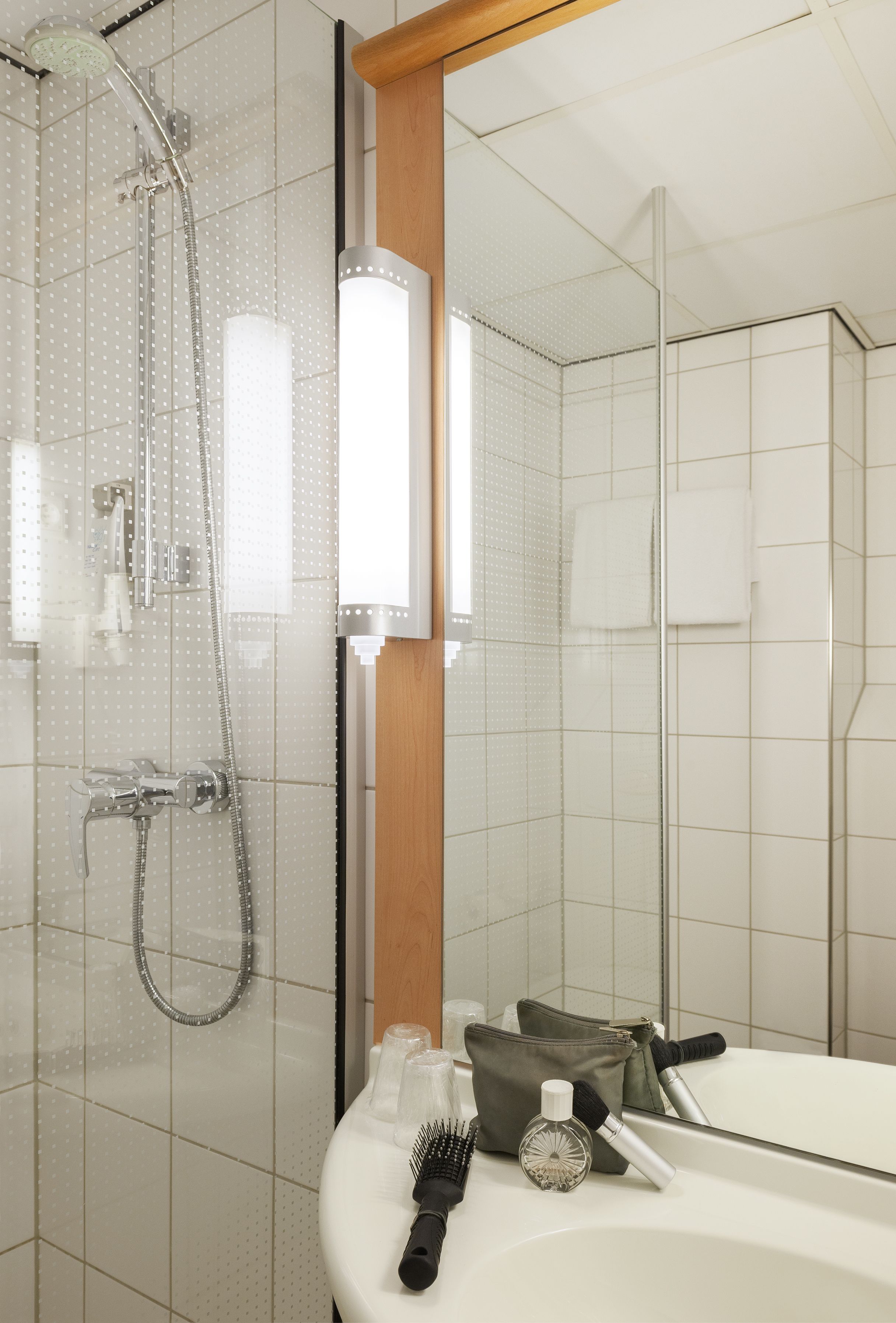 Une salle de bain avec une douche, un lavabo et un miroir.