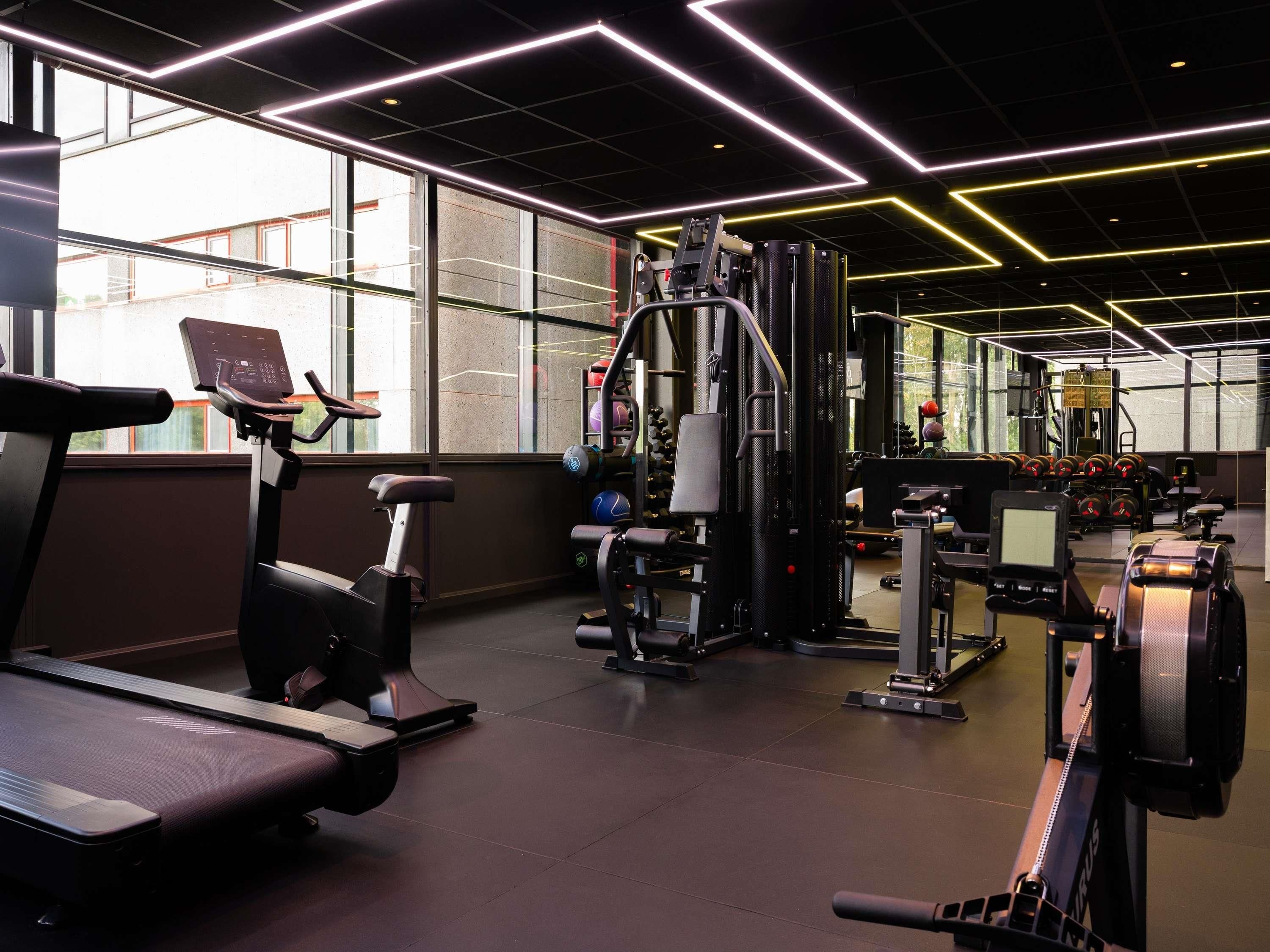A gym with exercise equipment, a treadmill, and a mirror.