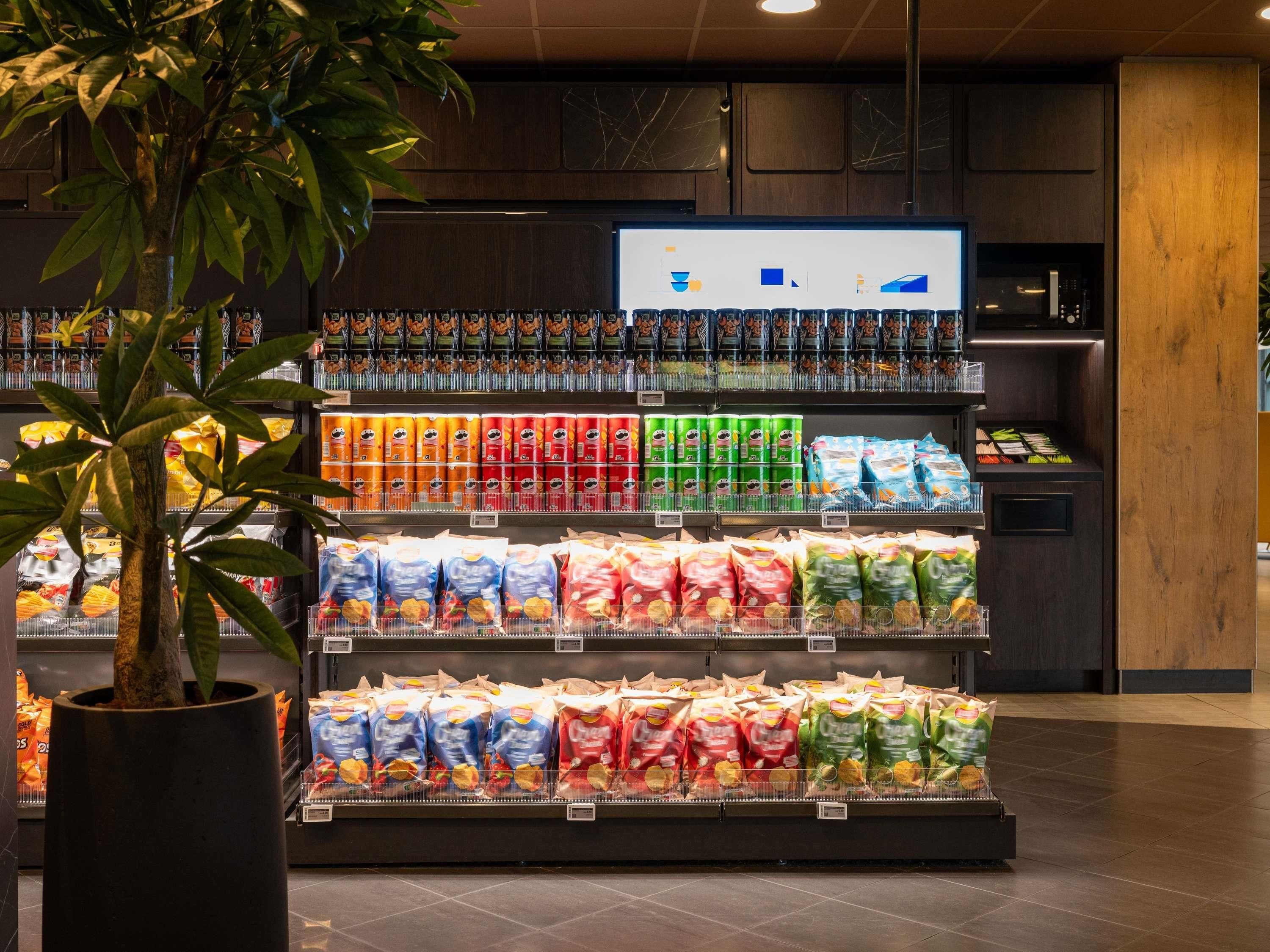 A grocery store aisle with various packaged goods and a digital display.