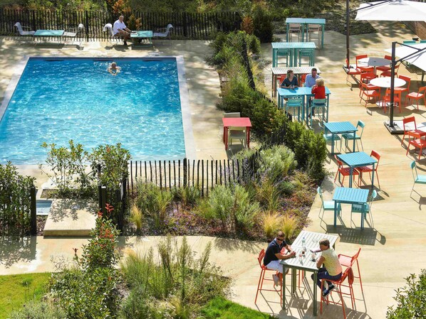 Una piscina al aire libre de temporada, sillones reclinables de piscina