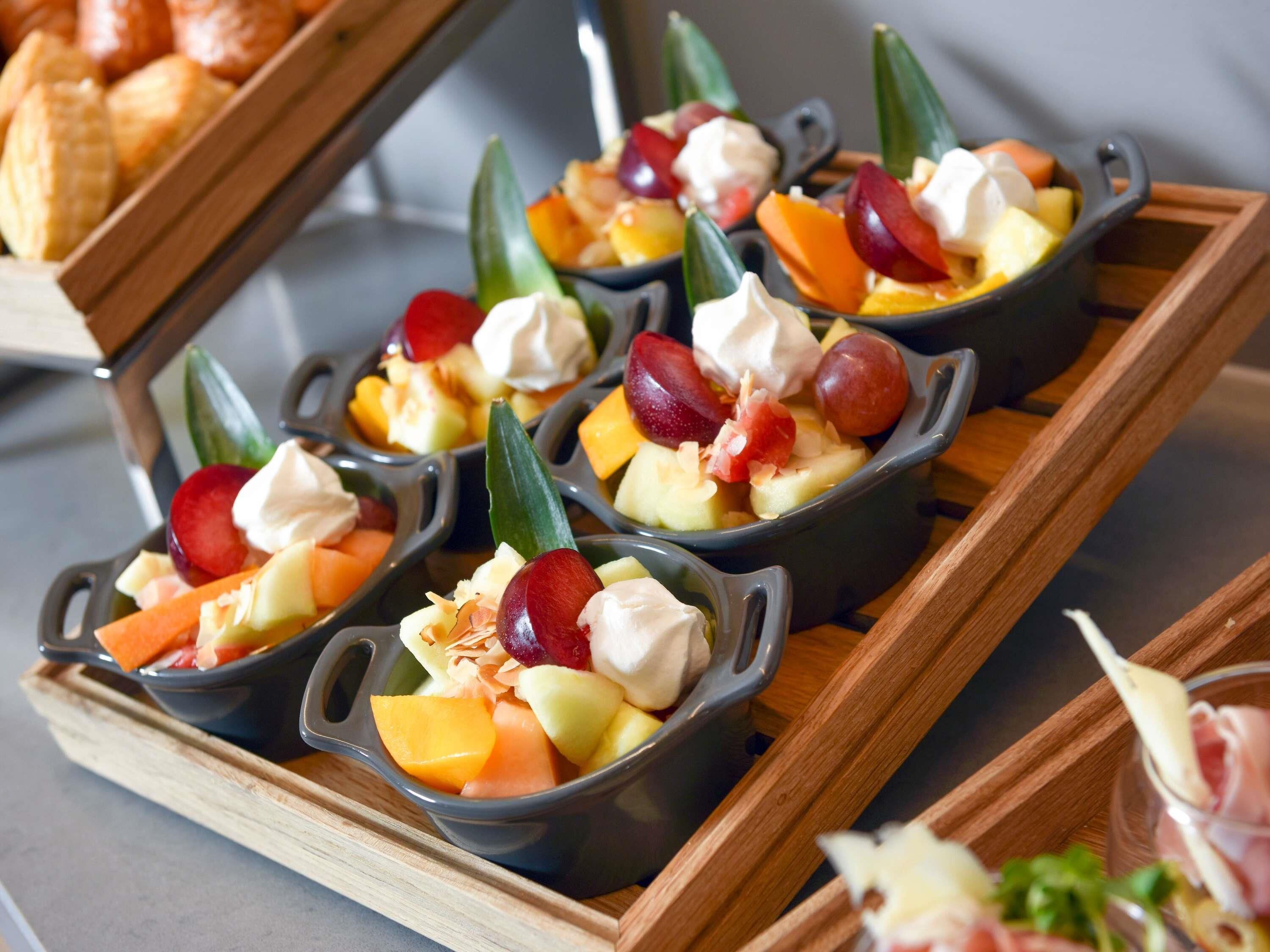 A tray with individual servings of fruit and cream in small bowls.