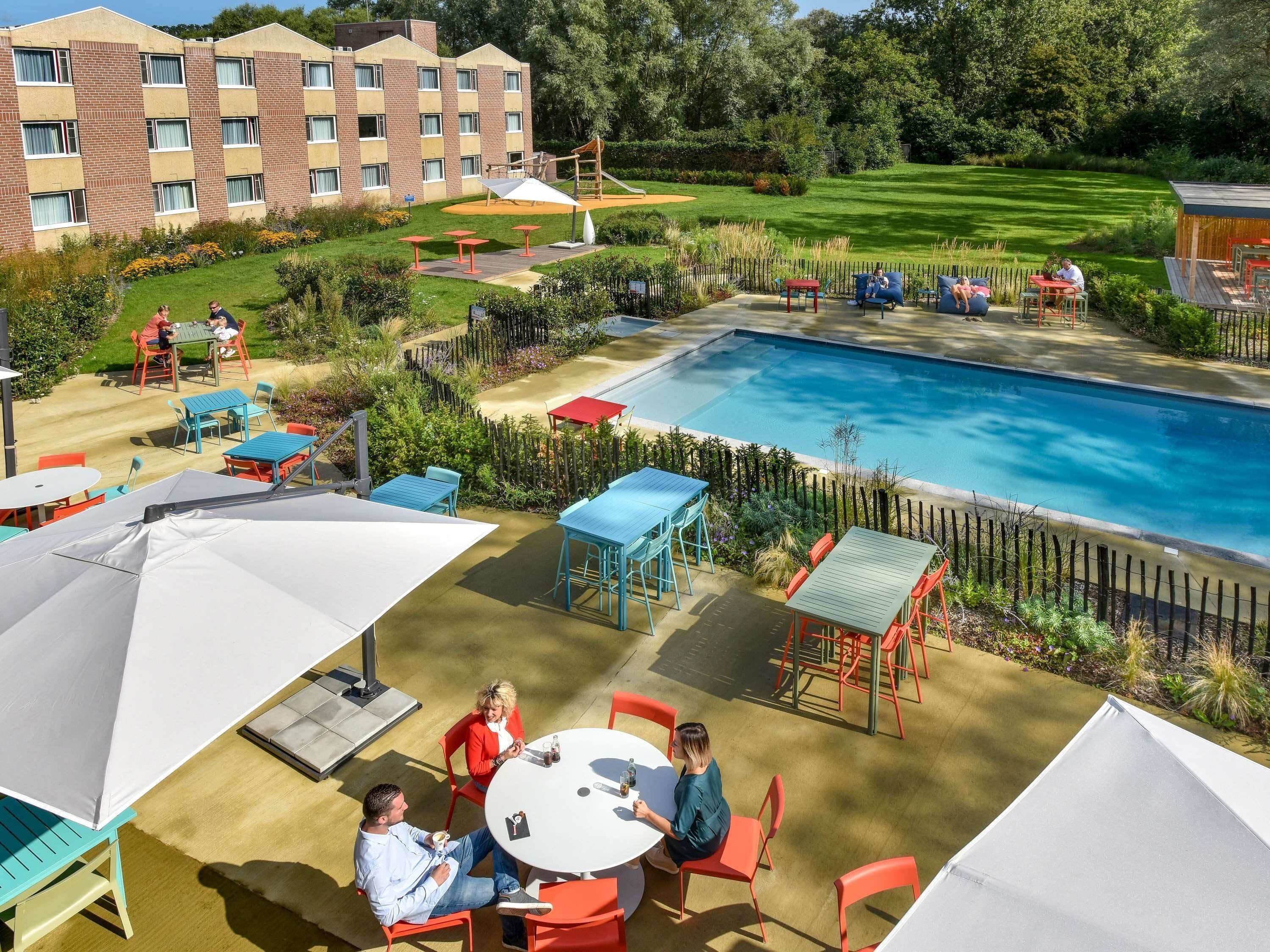 Una piscina al aire libre de temporada, sillones reclinables de piscina