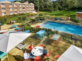 Una piscina al aire libre de temporada, sillones reclinables de piscina
