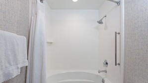Une salle de bain moderne avec une baignoire sur pieds, une douche et un porte-serviettes.