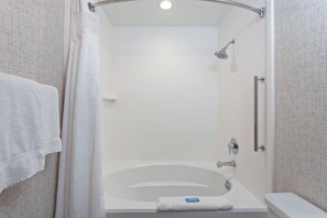 A modern bathroom with a freestanding bathtub, a showerhead, and a towel rack. - Holiday Inn Express Los Angeles Airport by IHG (Los Angeles)