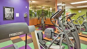 A gym with various exercise equipment, including treadmills and weight machines. - Holiday Inn Manhattan at the Campus by IHG (Manhattan)