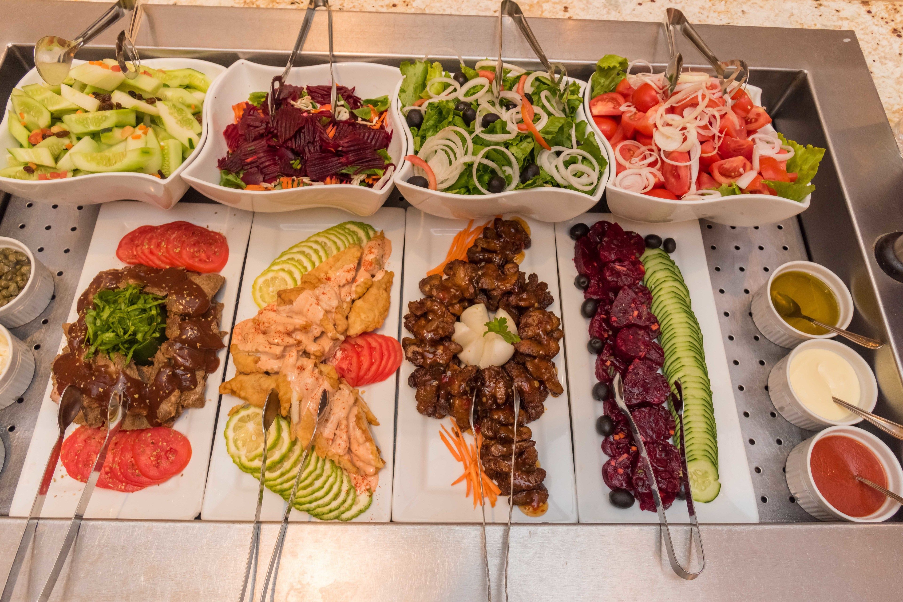 A buffet with various dishes including salads, meats, and vegetables.
