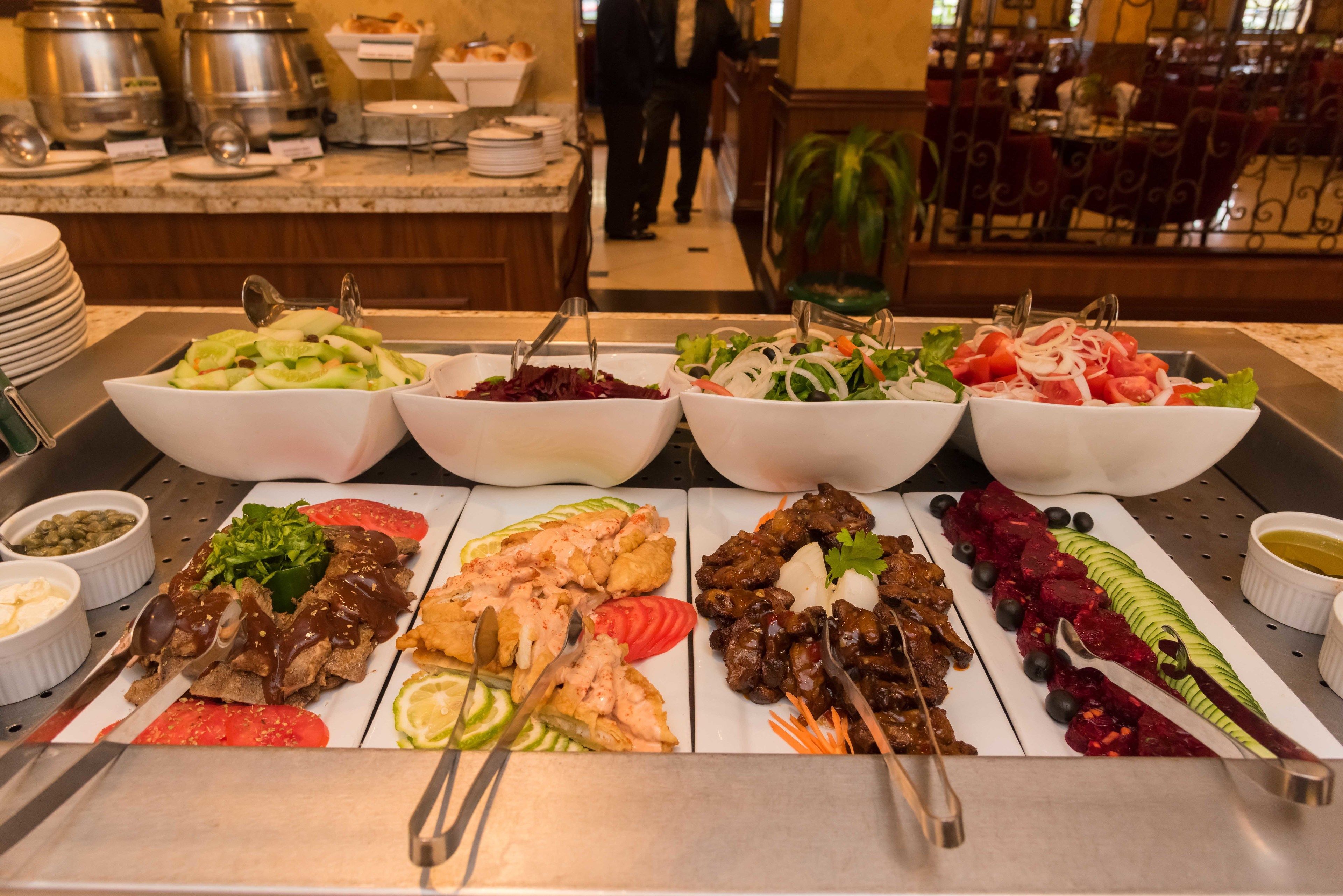 A buffet with various dishes including salads, meats, and vegetables.