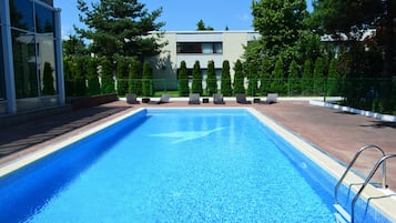 Una piscina al aire libre de temporada, sillones reclinables de piscina