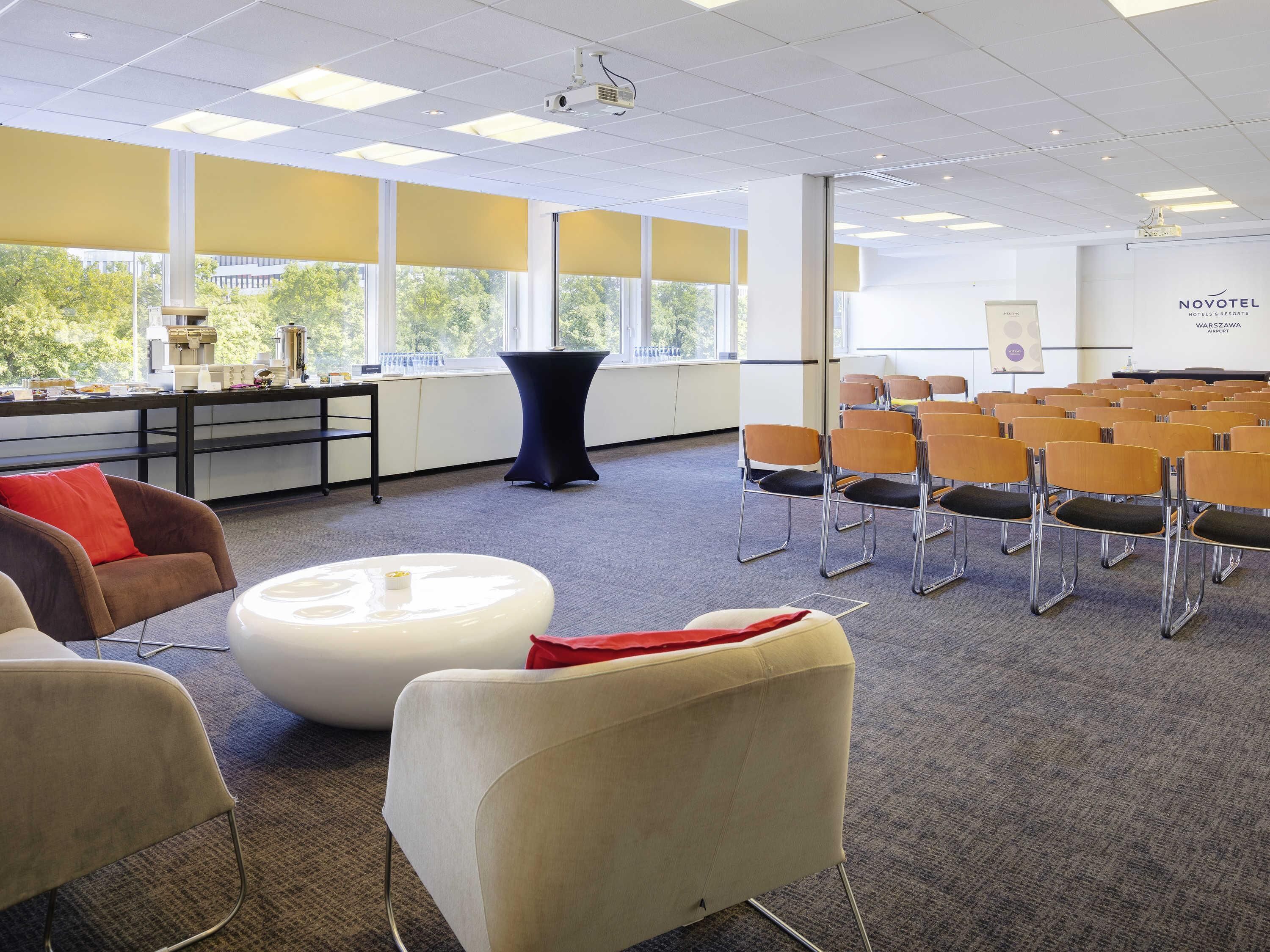 A conference room with a white table, chairs, and a projector.