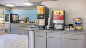 Una estación de café autoservicio con una cafetera Folgers Select Brew y un dispensador de bebidas de temática vintage.