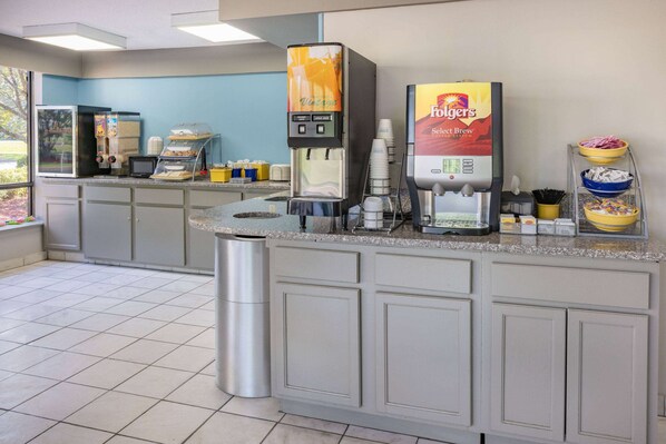 A self-service coffee station with a Folgers Select Brew coffee maker and a vintage-themed beverage dispenser.