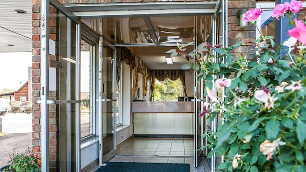 A hotel entrance with a glass door, a reception desk, and a number 731 sign above.