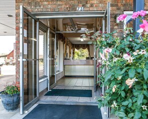 A hotel entrance with a glass door, a reception desk, and a number 731 sign above. - Rodeway Inn Sweetwater South (Sweetwater)