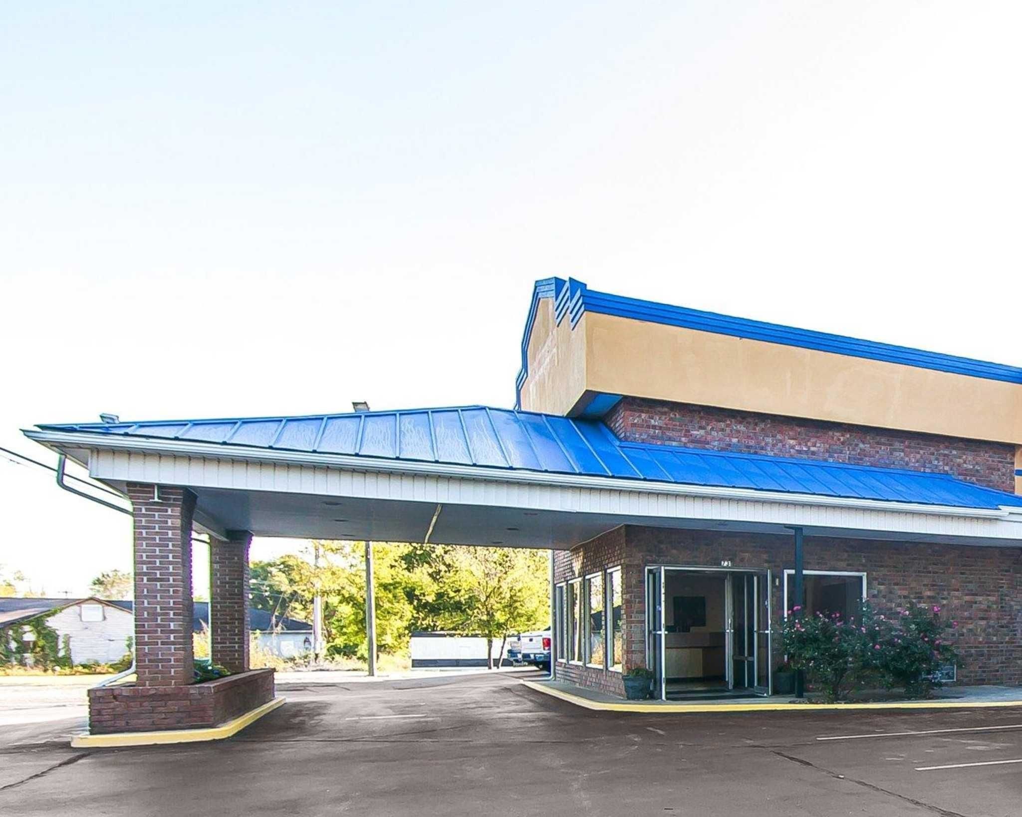 Un bâtiment doté d’un toit bleu et d’un espace d’entrée abrité.