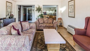 A living room with patterned sofas, a coffee table, and framed artwork on the walls.