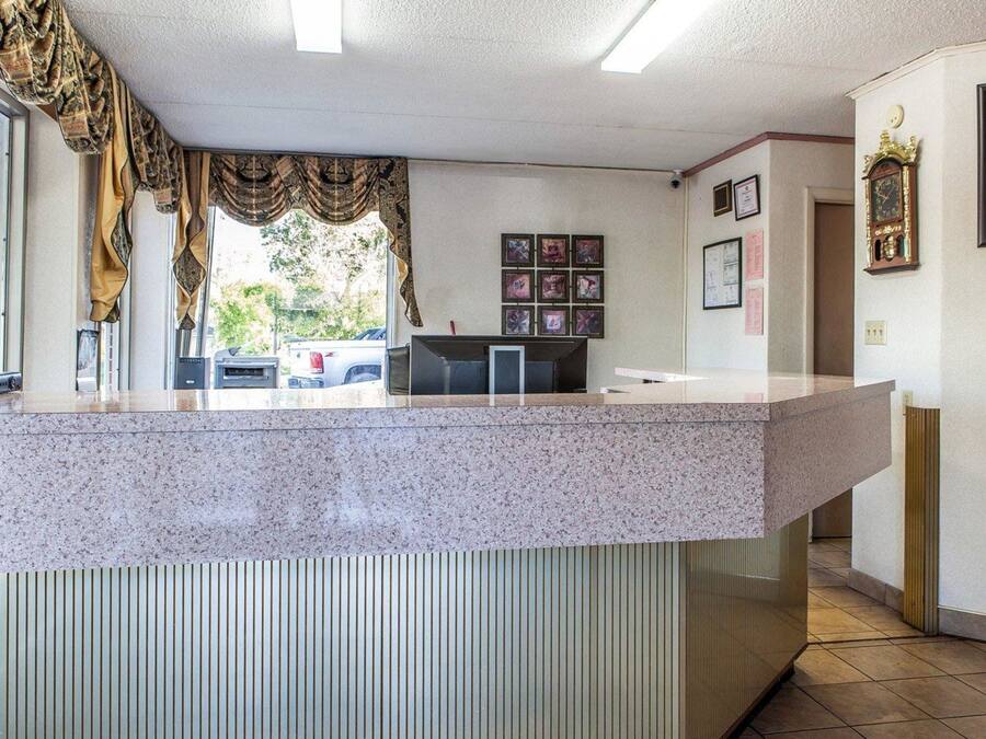 A reception area with a granite counter, framed pictures on the wall, and a clock.
