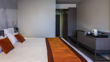 Una habitación de hotel con una cama, un escritorio y una cafetera.