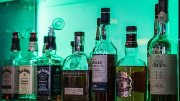 On peut voir une variété de bouteilles de whisky sur une étagère.