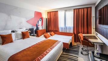 A hotel room with a large bed, a desk, a chair, a TV, and a painting on the wall.