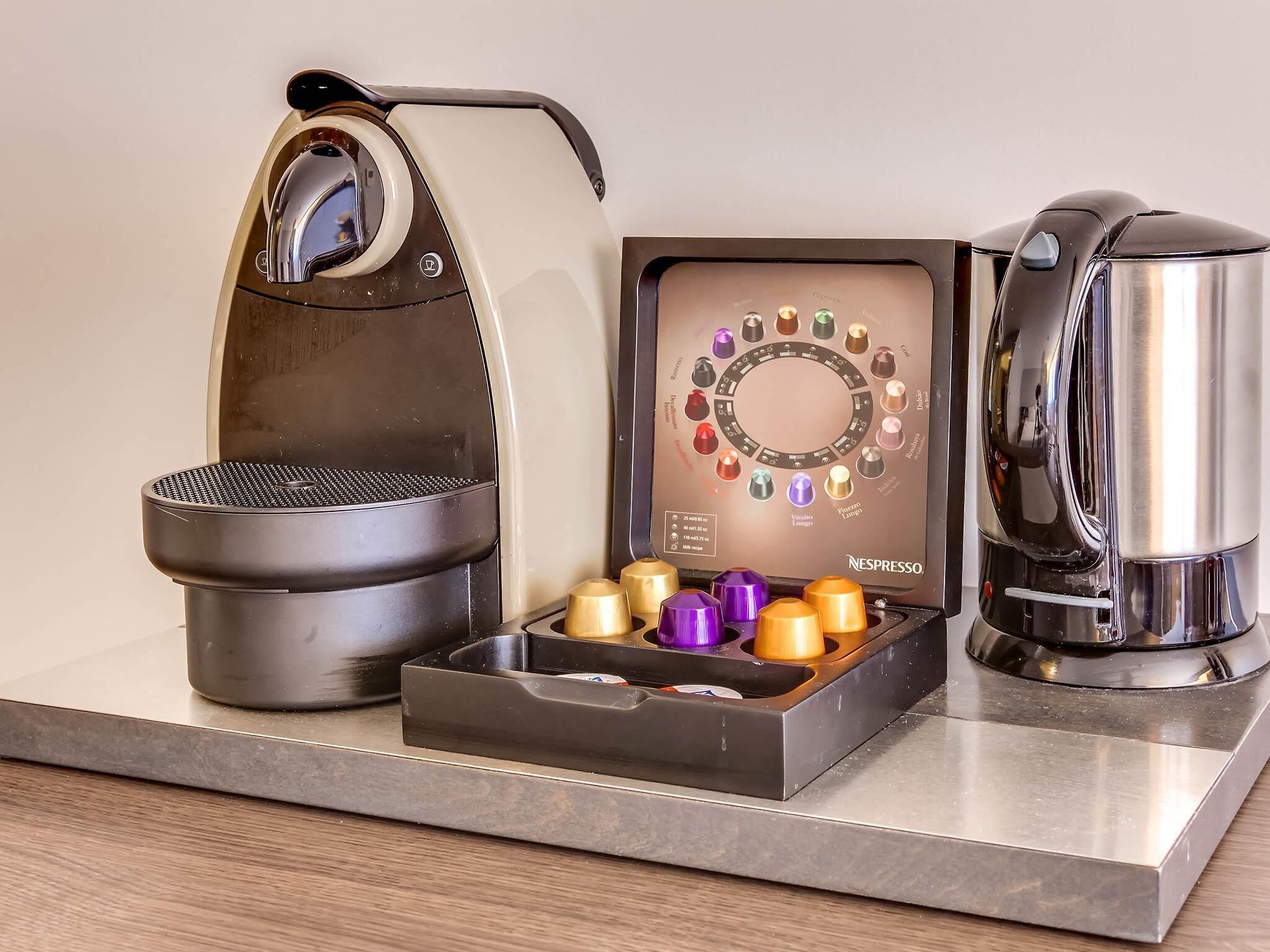 A coffee machine with a drip tray and a coffee pot on a countertop.