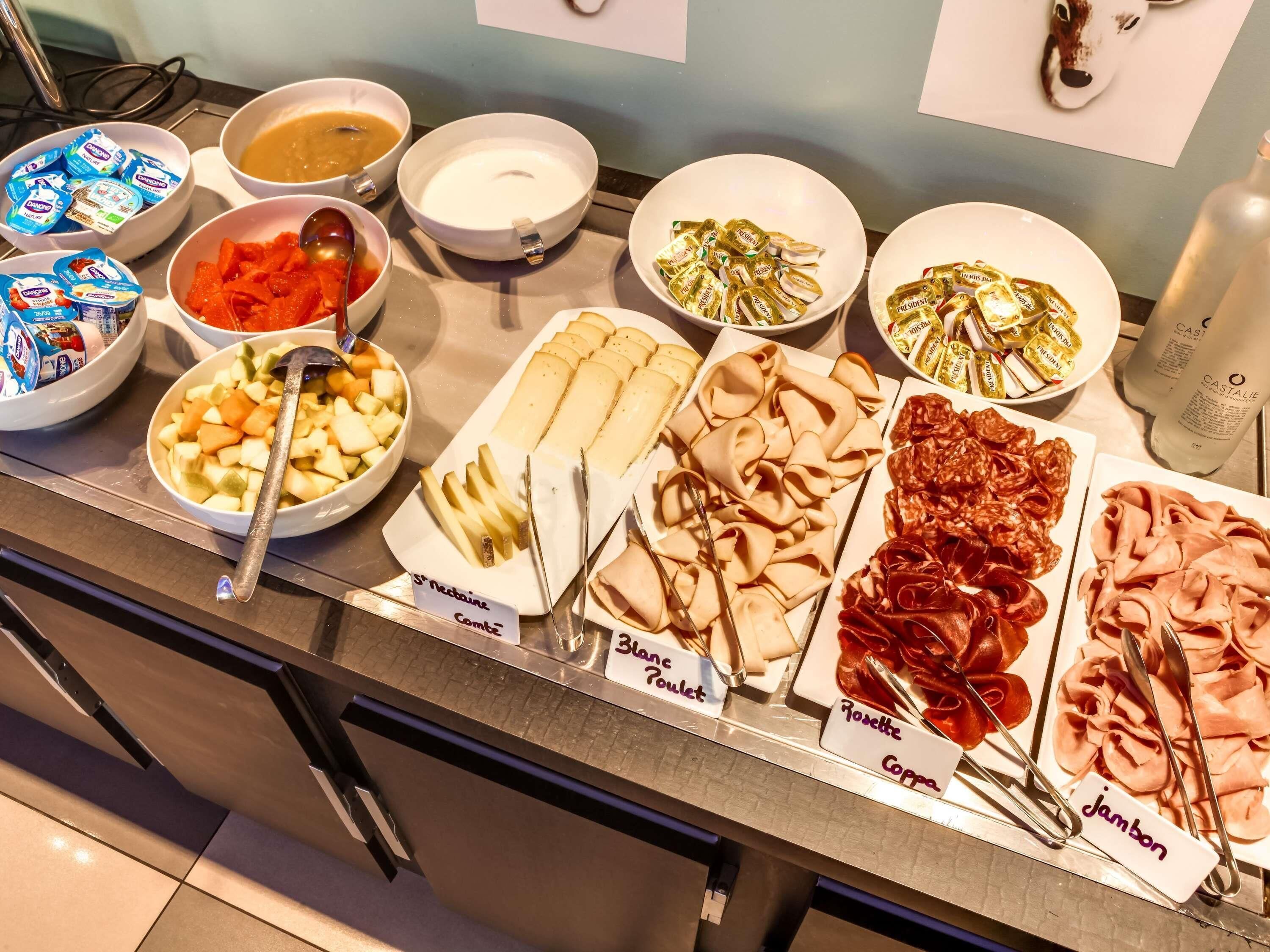En buffé med ett varierat utbud av mat, inklusive frukt, ostar och charkuterier.