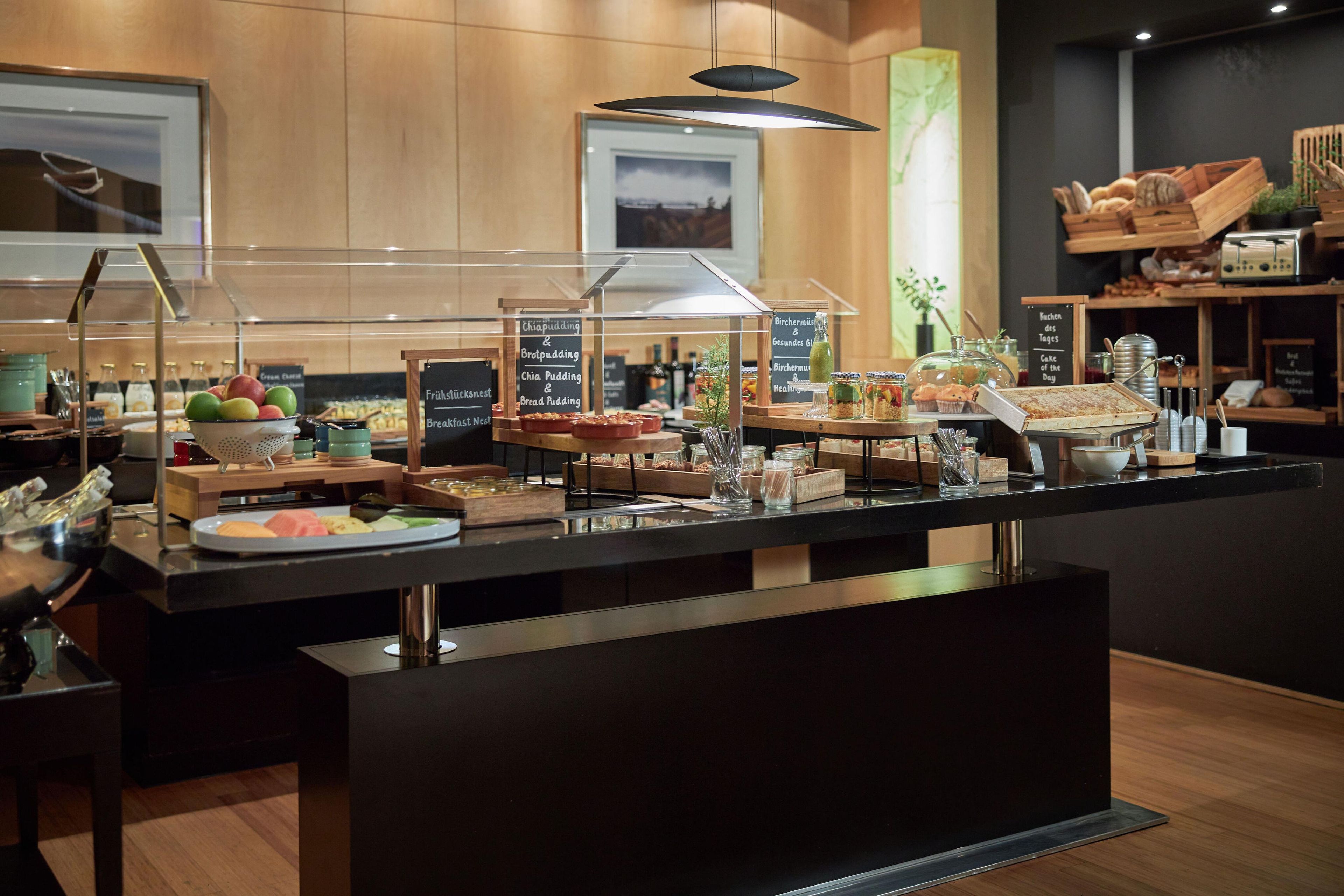 A buffet counter with various food options and a sign indicating breakfast items.
