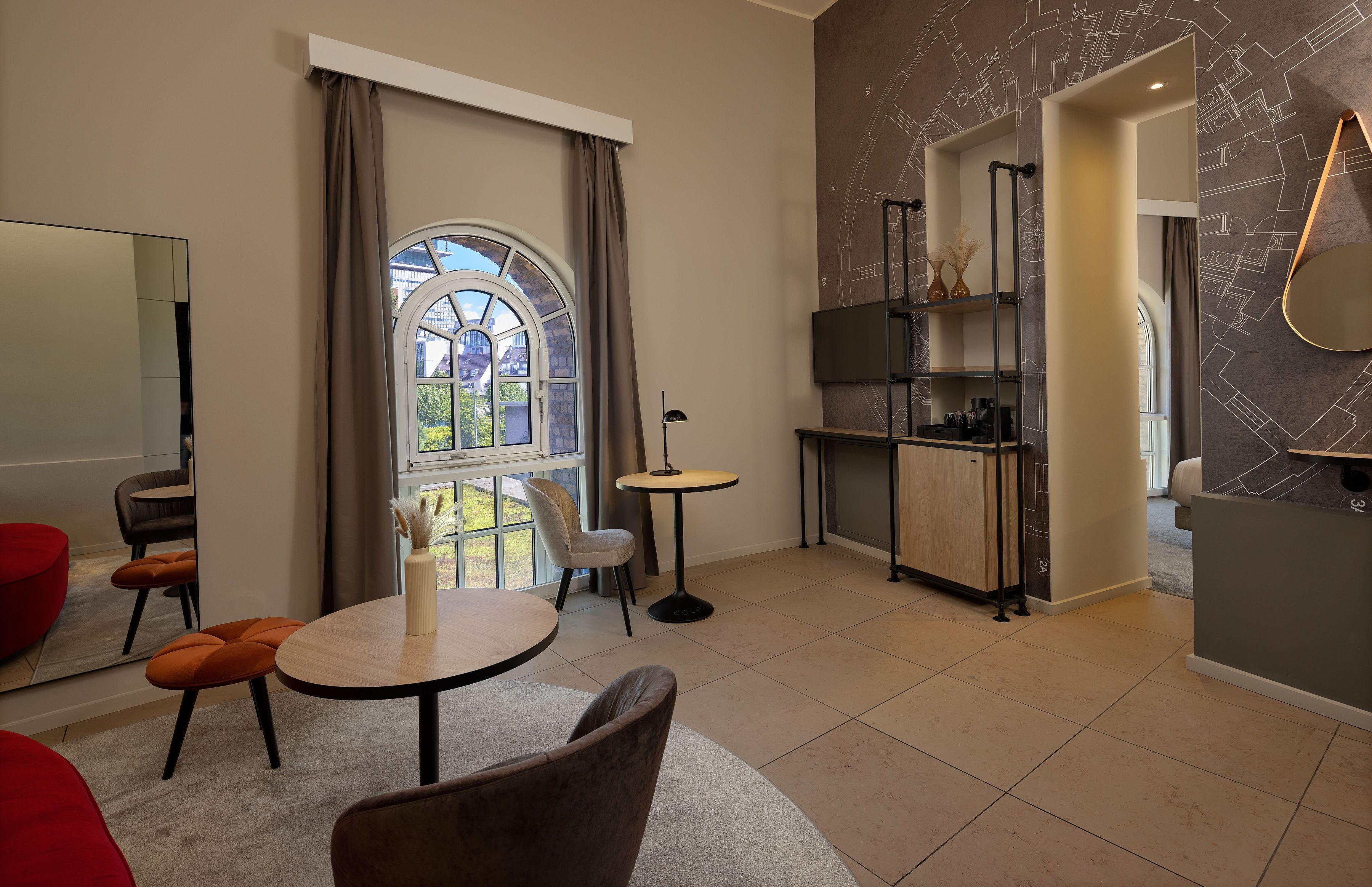 A modern living room with a dining area, a kitchen, and a large window with curtains.