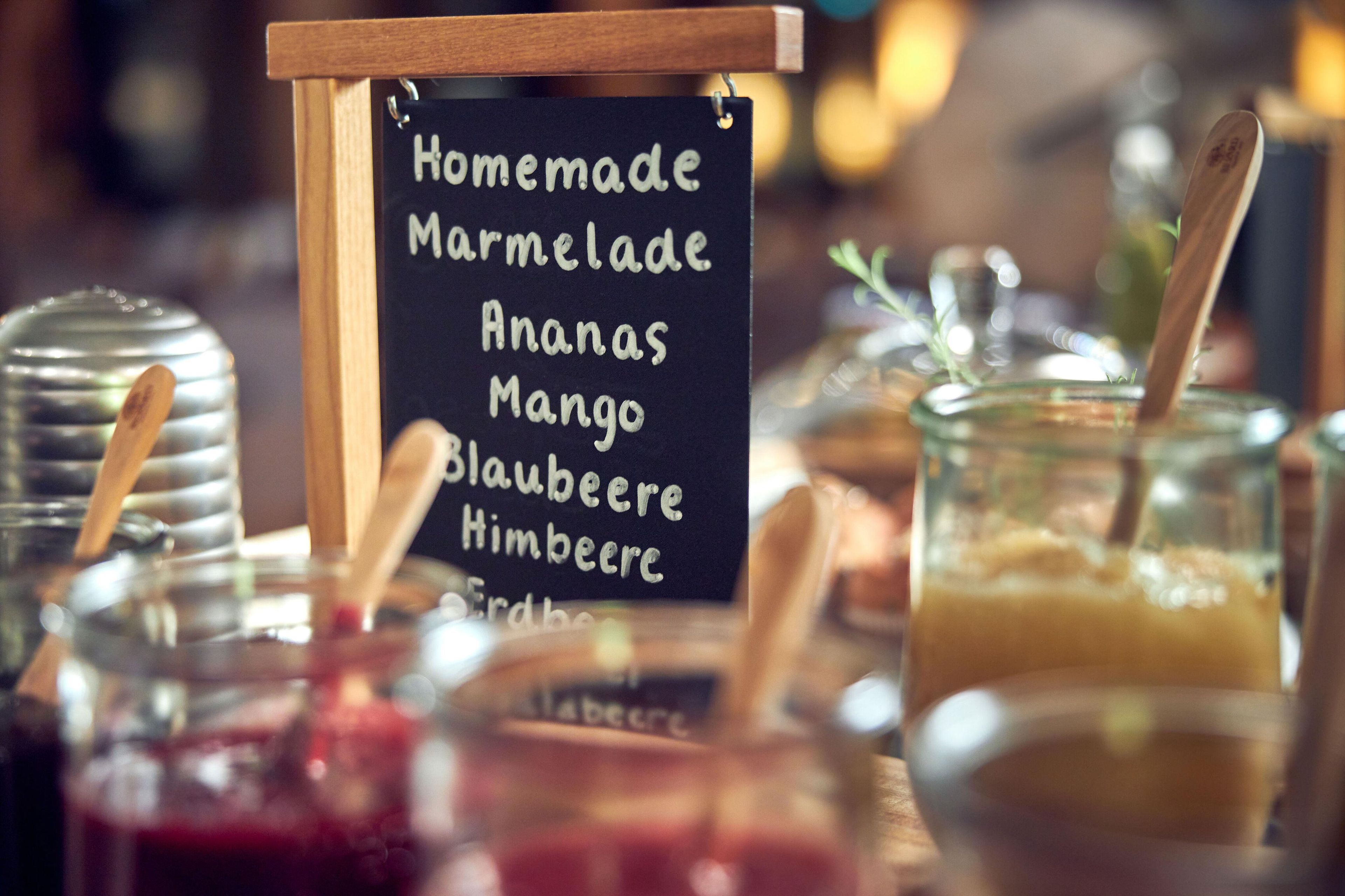 A sign listing homemade marmalade, ananas, mango, blaubeer, and himbeere.