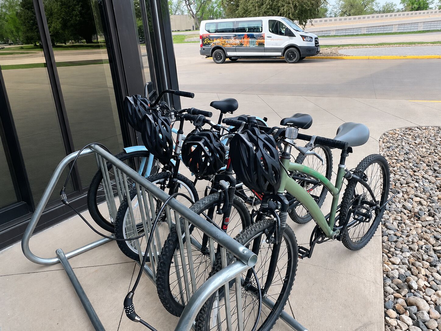 Cykler parkeret uden foran en bygning med glasdør.