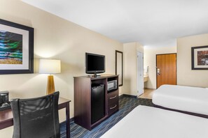 A hotel room with a bed, a desk with a chair, a television, a microwave, and a door leading to a bathroom. - Best Western Oglesby Inn (Oglesby)