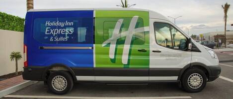 A Holiday Inn Express & Suites van parked in a lot.