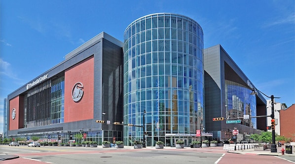 Un bâtiment moderne doté d’une façade en verre remarquable et d’un grand logo circulaire sur le côté.