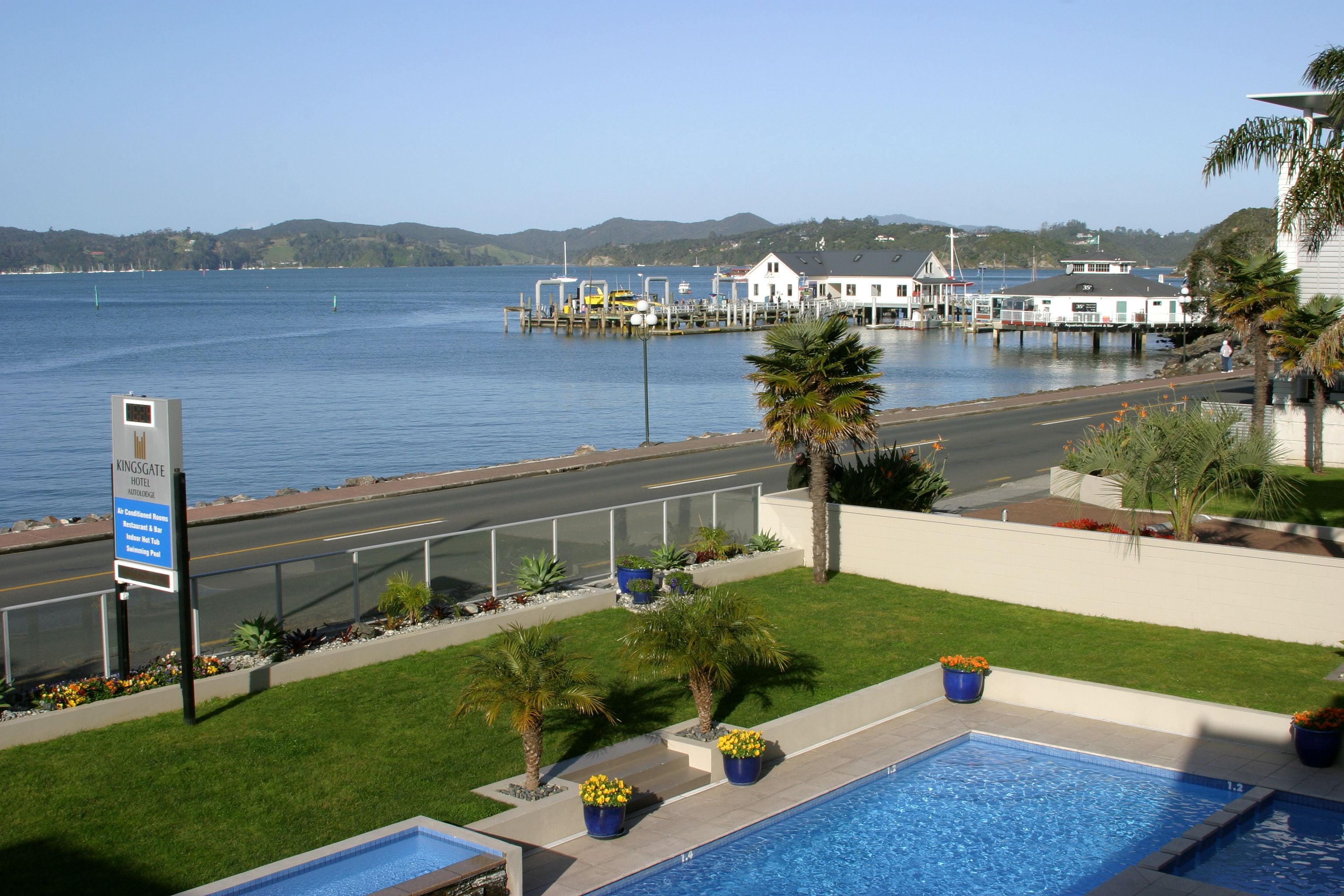 A hotel with a pool, a view of the water, and a sign indicating it is Kingsgate Hotel.
