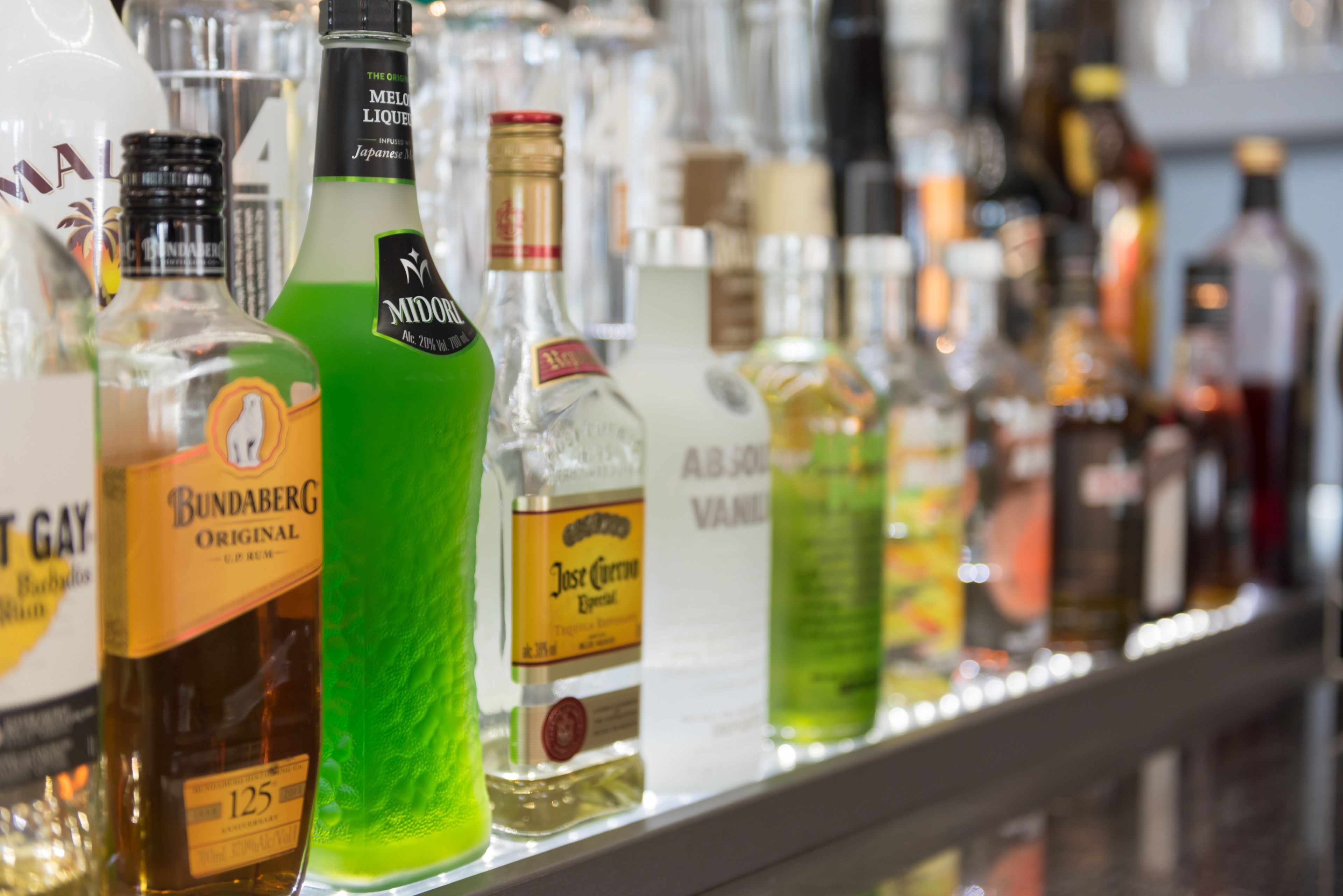 Variedad de botellas de licor en una estantería.