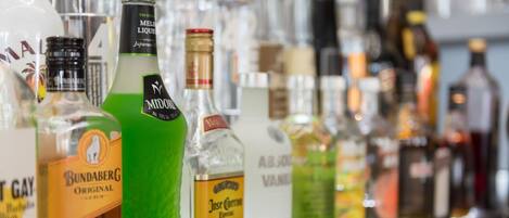 A variety of liquor bottles on a shelf.