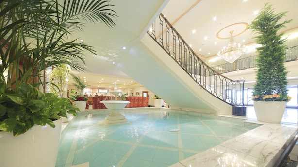 A spacious lobby with a central fountain, a staircase, and potted plants. - Hotel Nikko Princess Kyoto (Kyoto)
