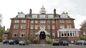 A large, historic building with a prominent tower and a sign reading "Station Hotel."