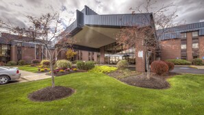 A modern building with a covered entrance, surrounded by well-maintained lawns and shrubs. - Comfort Inn Hall of Fame (Canton)