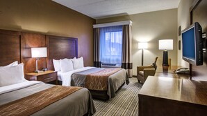 A hotel room with two beds, a desk with a telephone, a television, and a window with curtains. - Comfort Inn Hall of Fame (Canton)