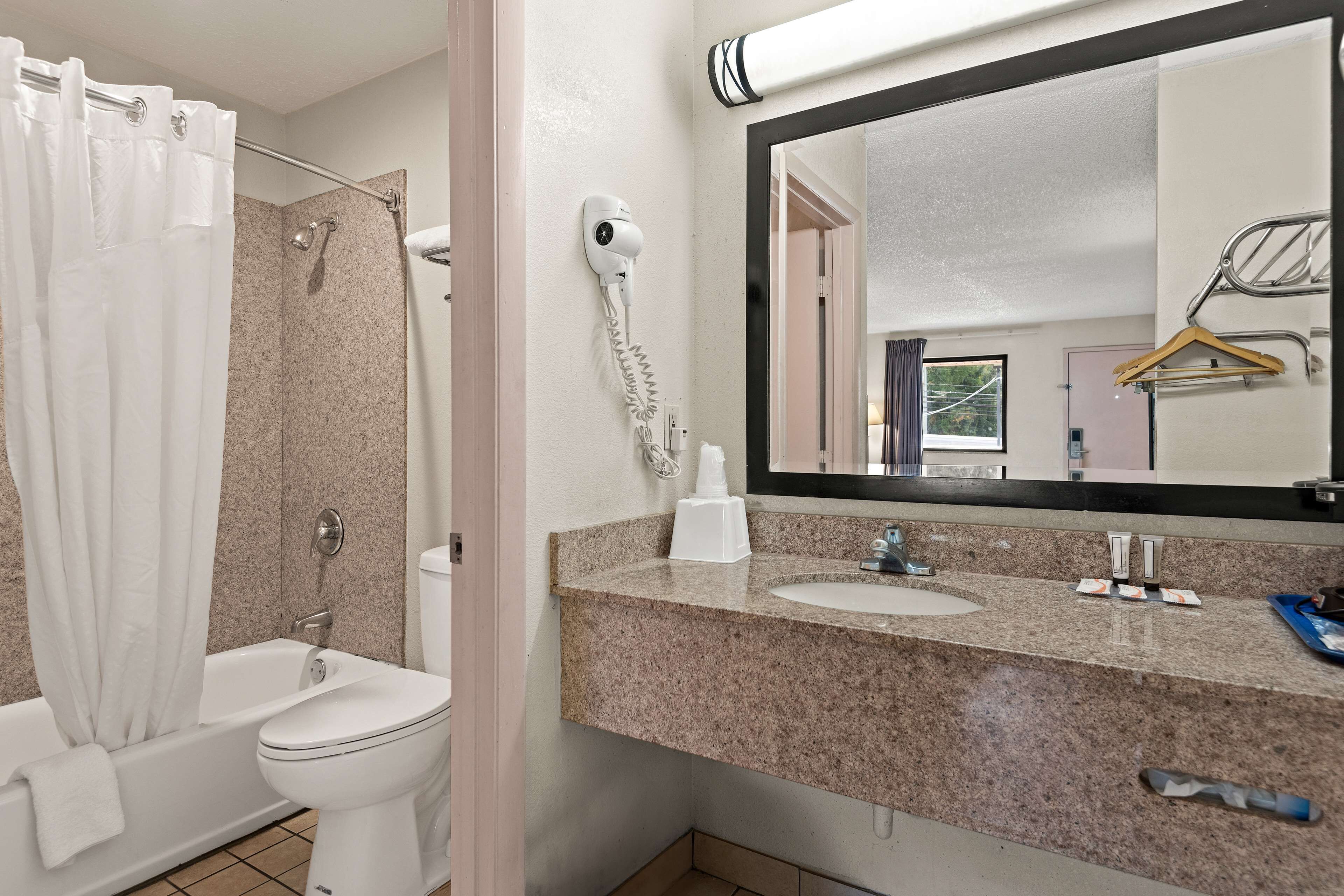 Une salle de bain avec douche, toilettes et lavabo.