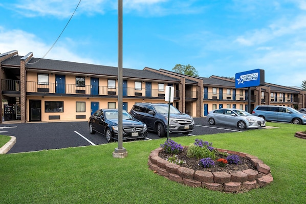 A motel with multiple rooms, a parking lot, and a sign indicating it is part of the Amerisuites network.