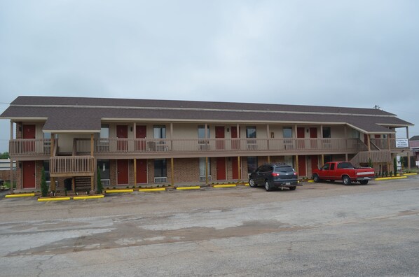Un motel composé d’un bâtiment à deux étages, de plusieurs chambres et d’un espace de stationnement pouvant accueillir deux véhicules.