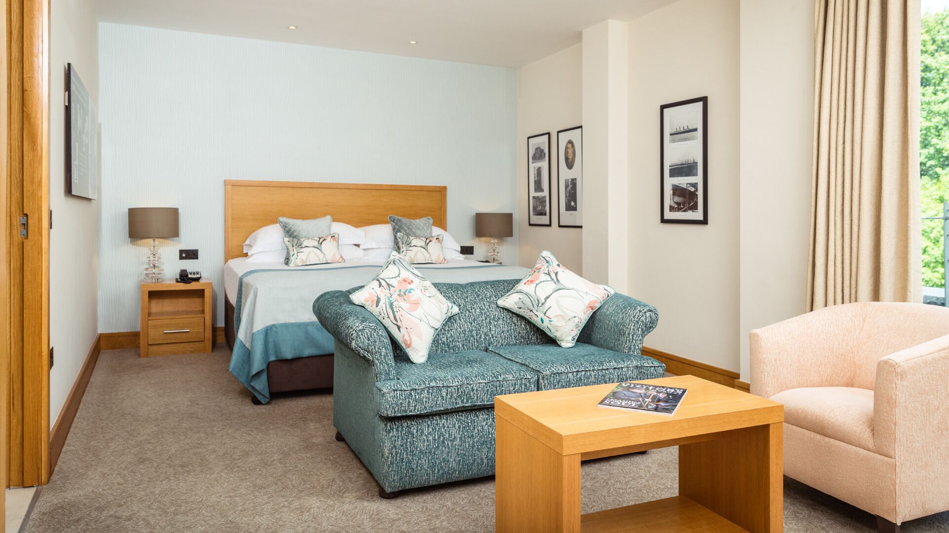 Une chambre d’hôtel avec un lit, deux canapés, une table basse et une chaise.