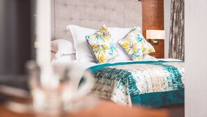 A neatly made bed with a patterned bedspread and two decorative pillows.